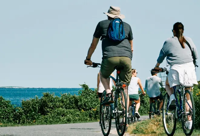 people riding bicycles near the ocean