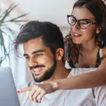 two people looking at a laptop together