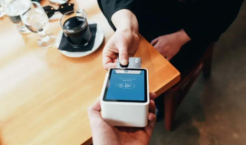 Man paying for coffee with his card on mobile payment machine