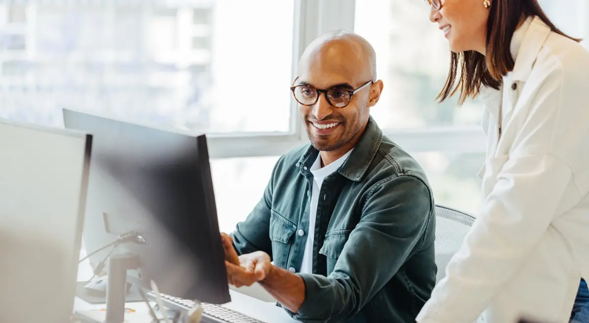 man and woman looking at computer