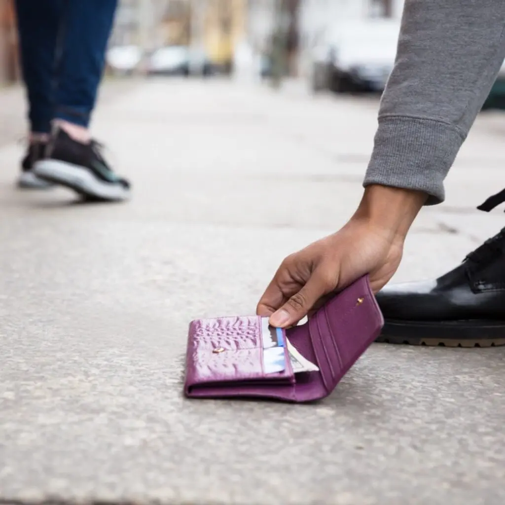 person picking up dropped wallet