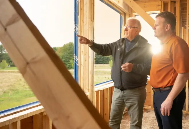 two people in a building under construction, looking out the window