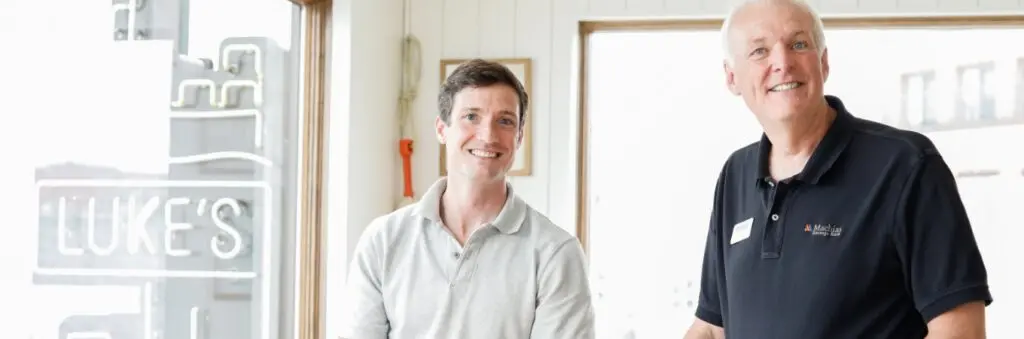 a banker smiling with another person for a photo