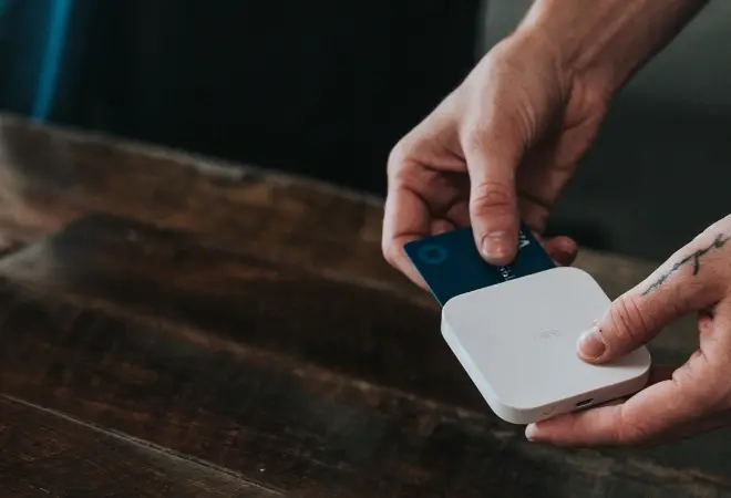 a person putting a card into a small credit card reader