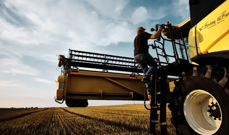 man getting off tractor in a field