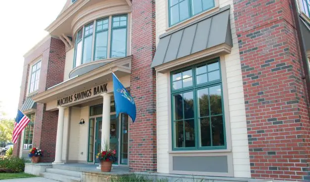 Machias Savings Bank building with two flags hanging from the front