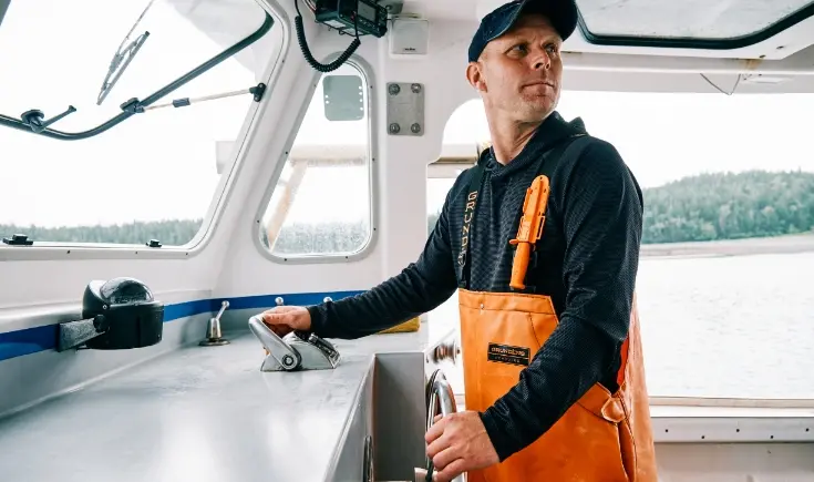 man in hat steering a boat