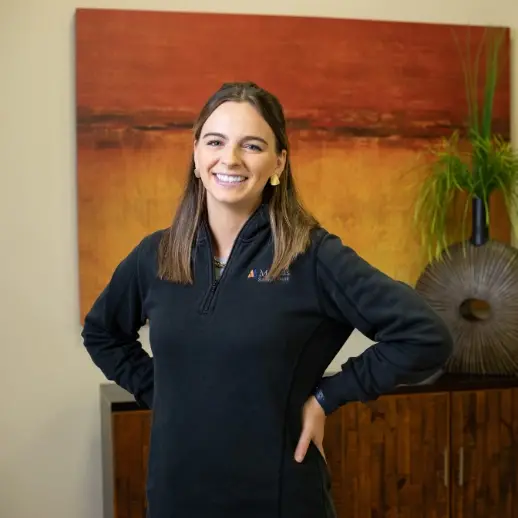 smiling woman in a bank, with a black jacket on