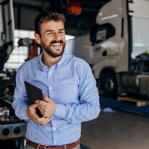 man smiling while holding tablet