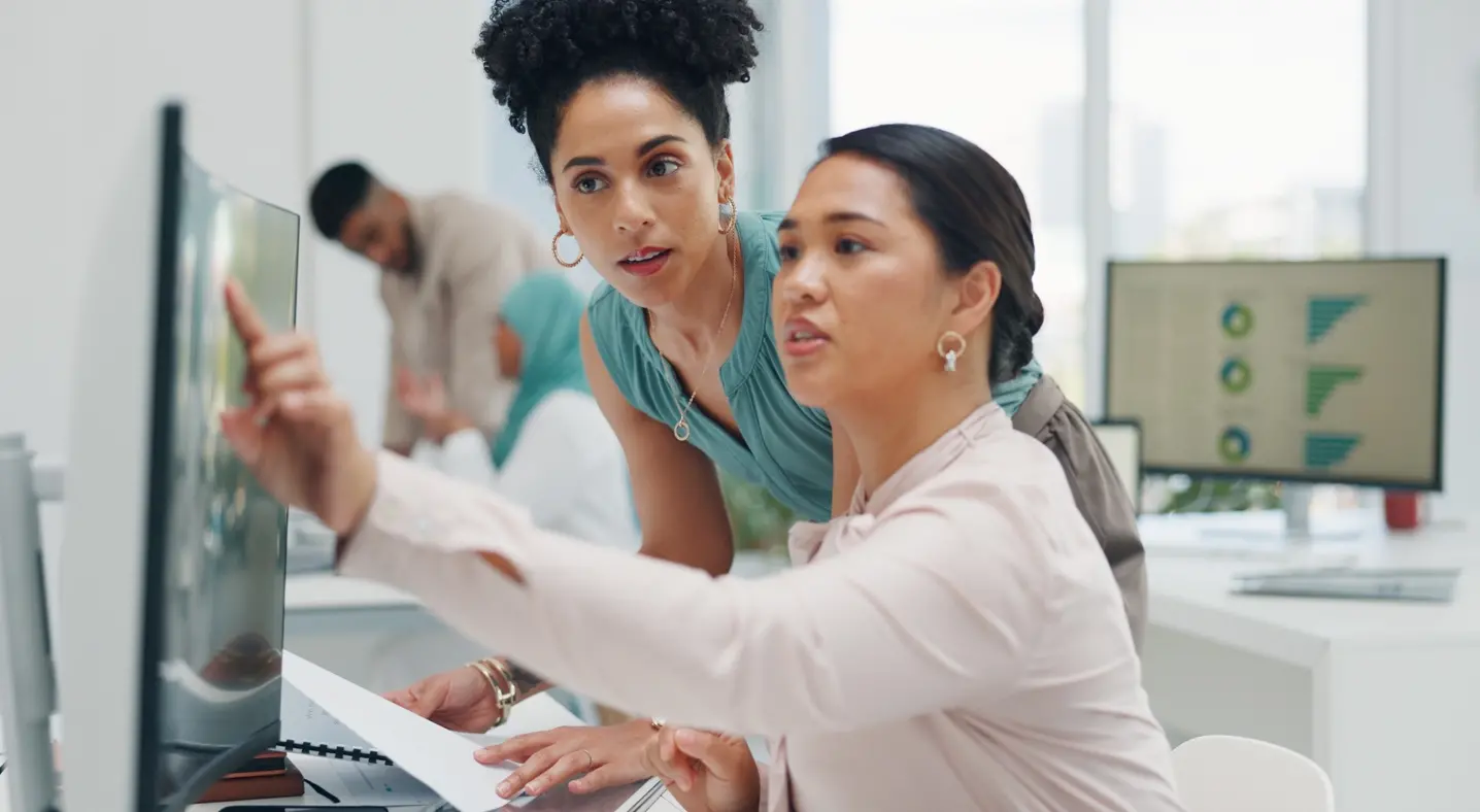 two women looking at computer monitor