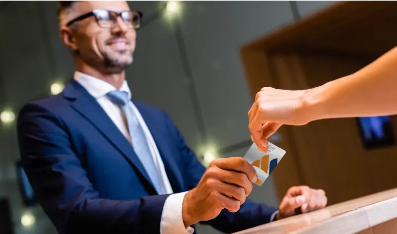 a person handing a credit card to a business man