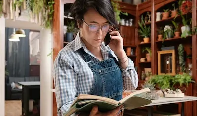 women on the phone looking at book