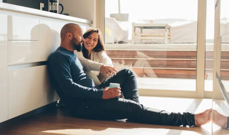 a couple sitting on the floor smiling