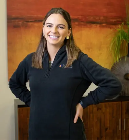 smiling woman in a bank, with a black jacket on