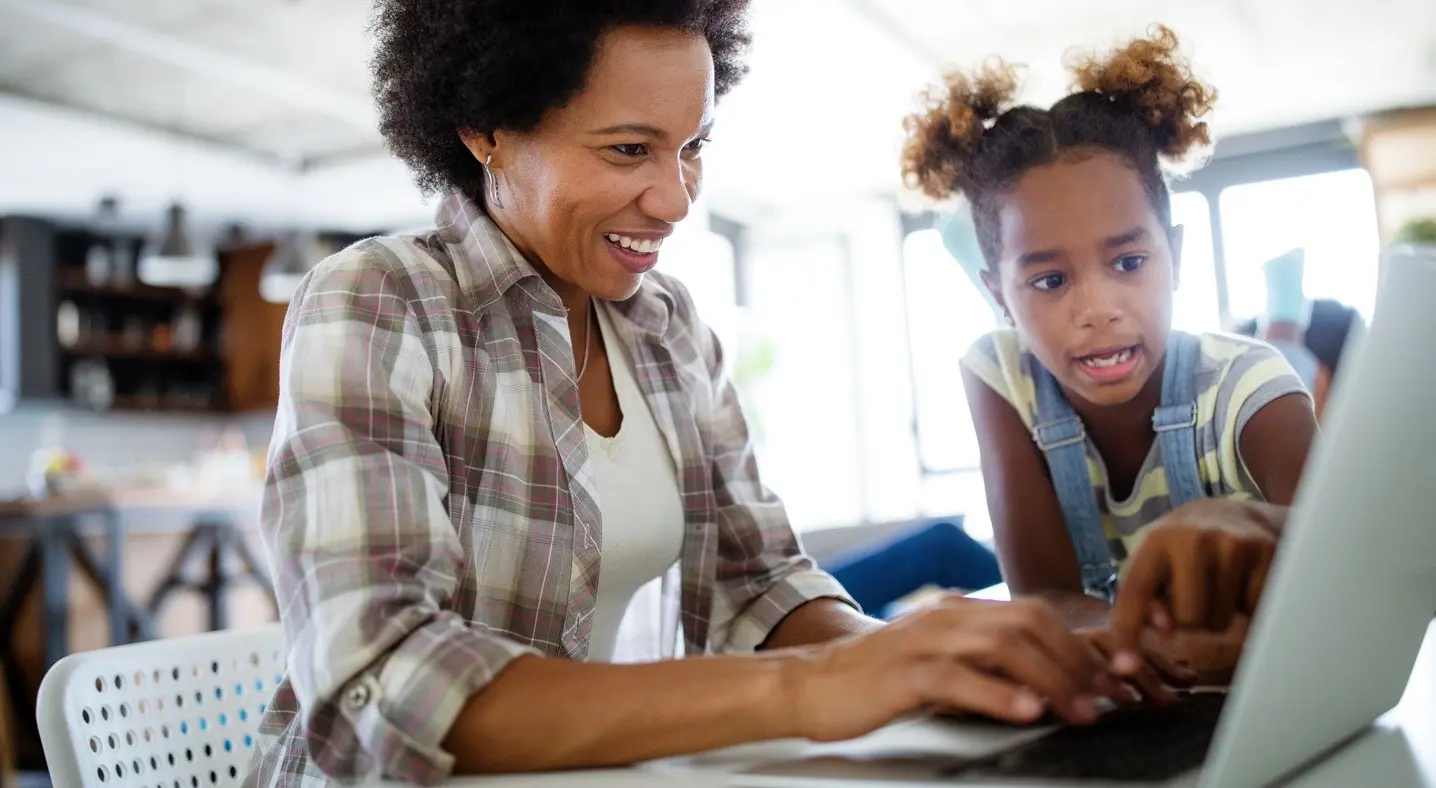 mother and daughter looking at laptop