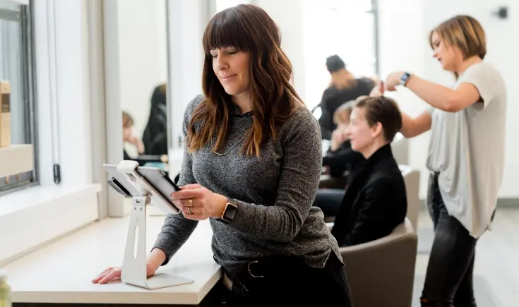 woman viewing tablet in salon