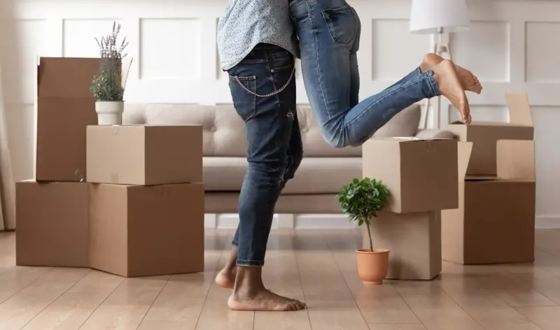 a couple who just moved into a home with unpacked boxes in the background