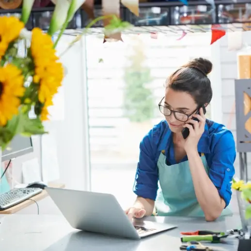 woman on phone call while on laptop