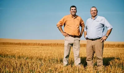 Two business men in a field smiling