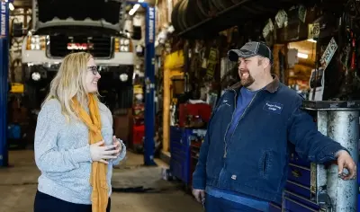 Small Business owner standing in his garage talking to a woman