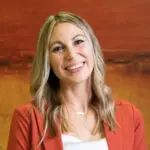 a woman in a bank dressed in professional attire with a happy expression