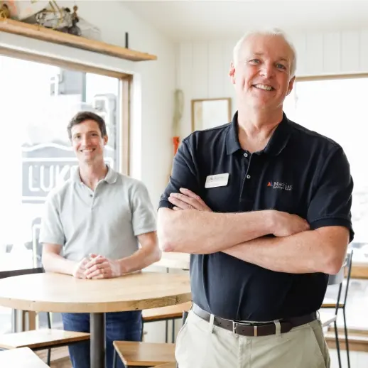 two men standing in a business smiling
