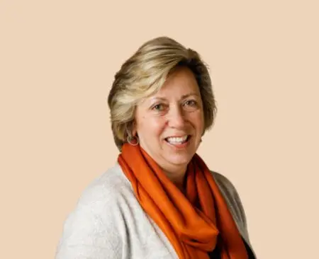 smiling woman with short hair in a white blouse and an orange scarf