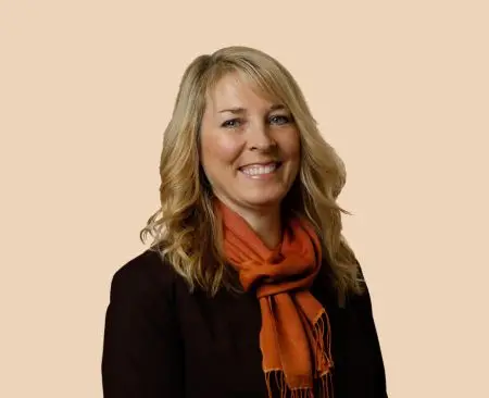 woman smiling wearing black top and orange scarf