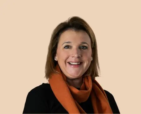 woman smiling wearing black top and orange scarf
