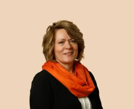 smiling woman with short hair in a black blouse and an orange scarf