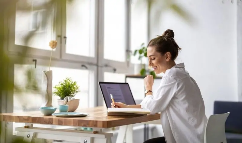 woman with notebook and open laptop