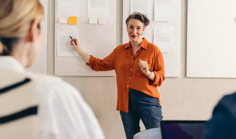 person in an orange shirt presenting their ideas