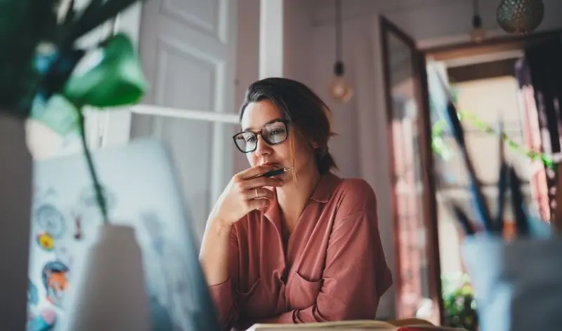 thinking woman with open laptop