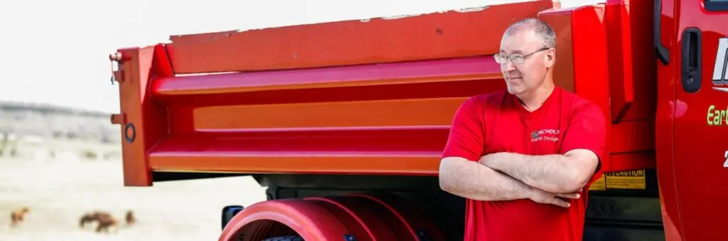 Man in red shirt standing by red truck