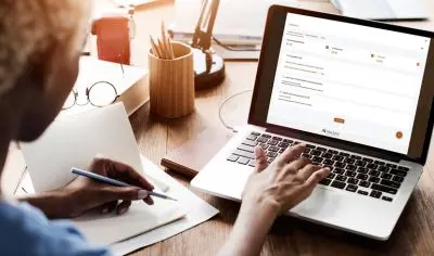 woman typing on laptop.