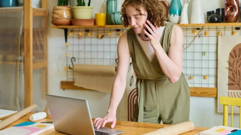 business owner on the phone while using their laptop