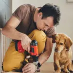 man drilling screw into wood