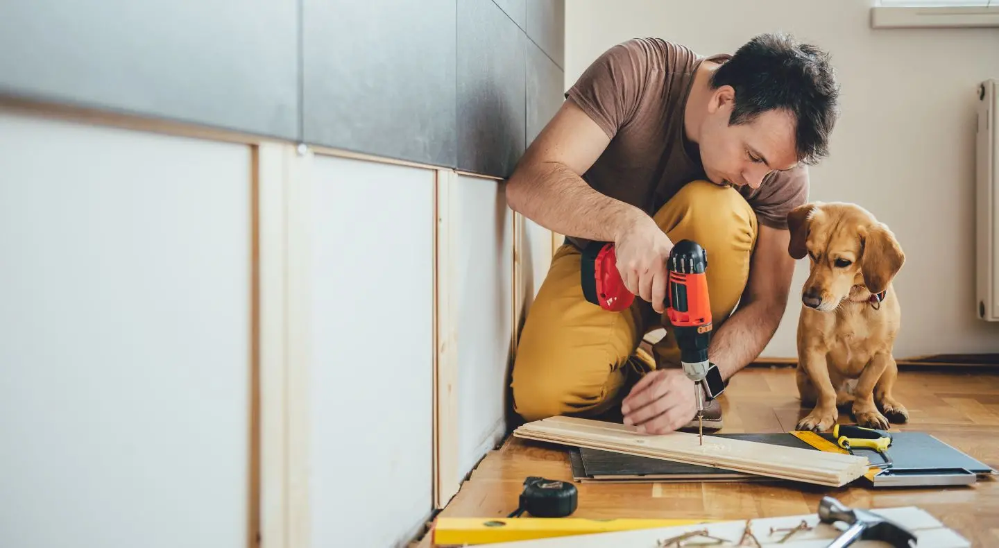 man drilling screw in wood