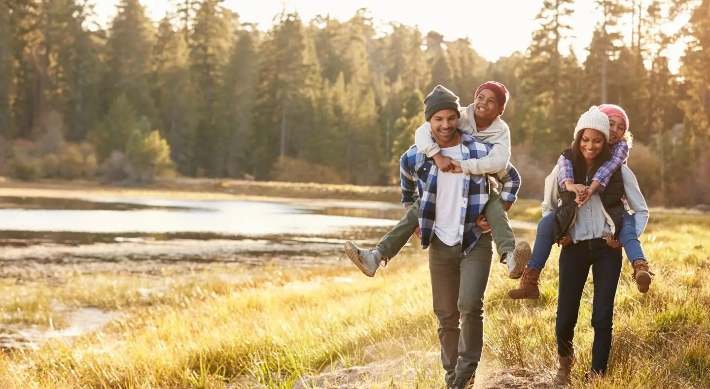 Man and woman walking through a field with kids