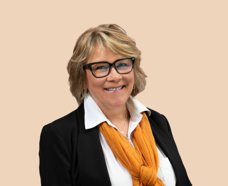 woman smiling wearing white button up with orange scarf and black blazer